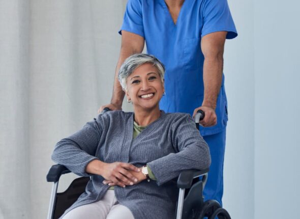 Medical assistant helps patient maneuver in wheelchair