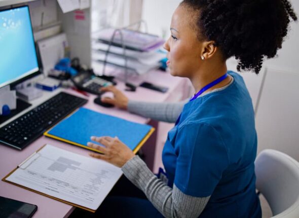 Medical office assistant working at computer