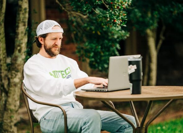 Unitech training academy online student on computer outside